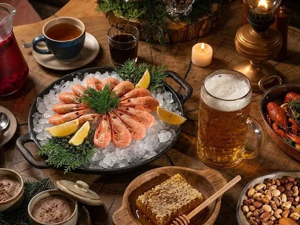 Стол с креветками на льду, раками, мёдом в сотах, орехами и напитками